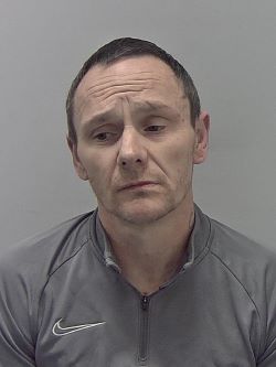 White male, brown hair, wearing grey shirt. 