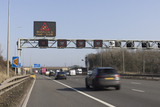 Car driving on motorway with gantry showing red X sign