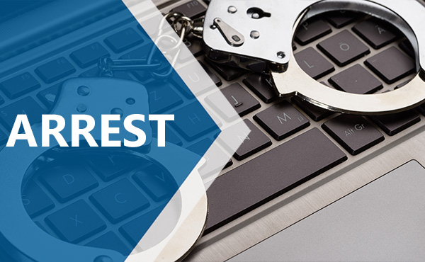 Picture of handcuffs on a laptop keyboard - Wording arrest on a blue arrow